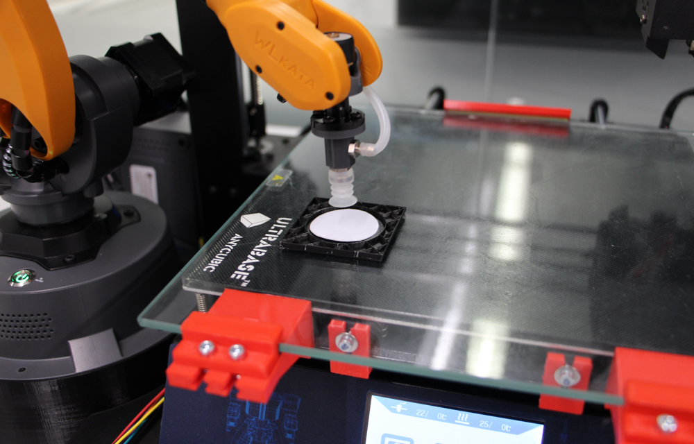 The robot arm inserts the RFID tag into the 3D-printed component. (Photo: IPH)