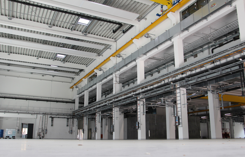 eine leere Fabrikhalle, mit Stahlträgern und Kabeln.