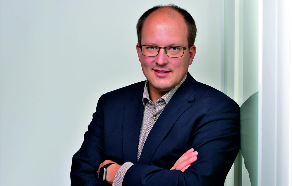 Das Portraitfoto zeigt Dr.-Ing. Christoph Lotz. Er trägt einen schwarzen Anzug und eine Brille.